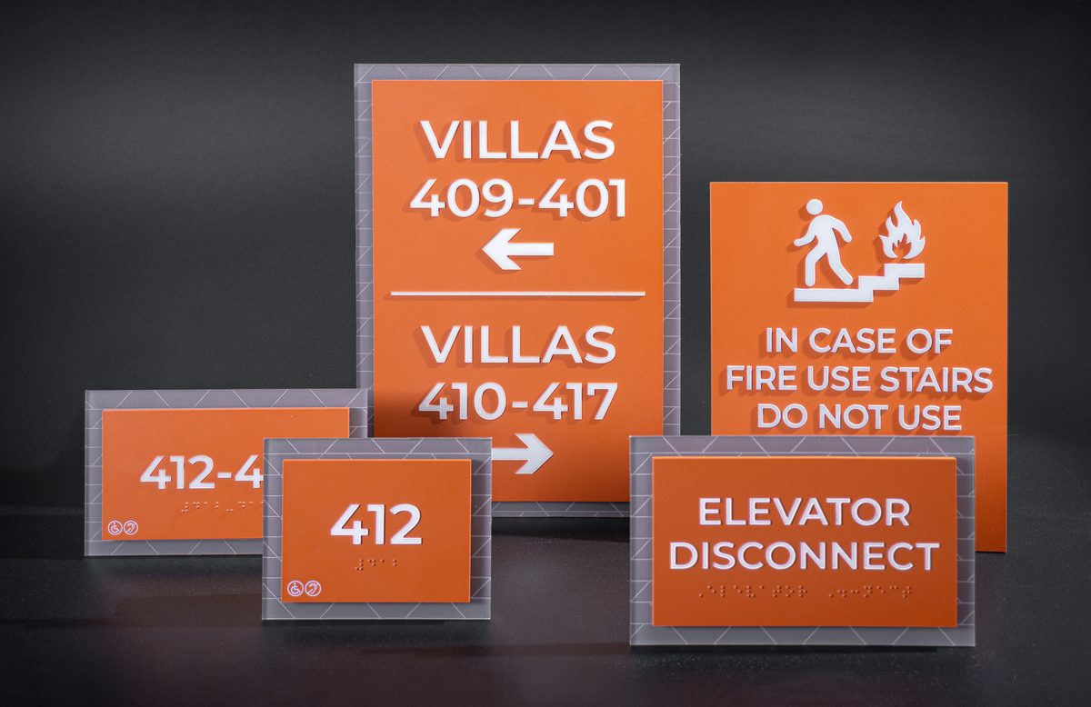 Complete orange villa signage system including directional wayfinding, unit IDs, fire safety, and elevator disconnect signs